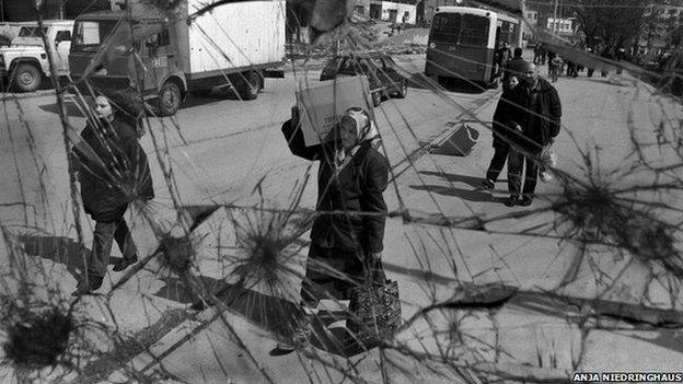 People in Sarajevo head home with food they have obtained from an aid agency