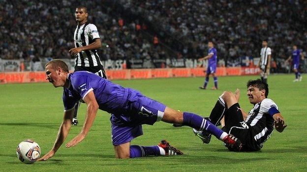A Tottenham player is tackled by a Salonika player