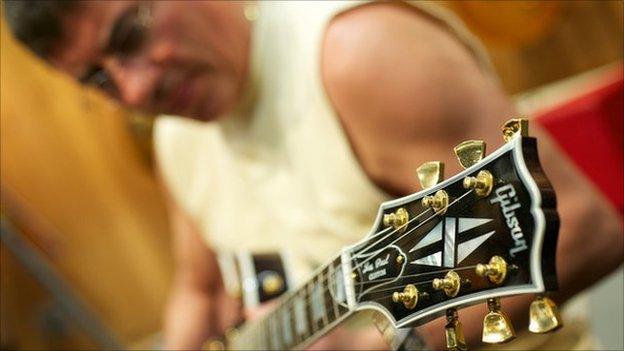 Billy Jack tests a Gibson Les Paul guitar in a Nashville shop