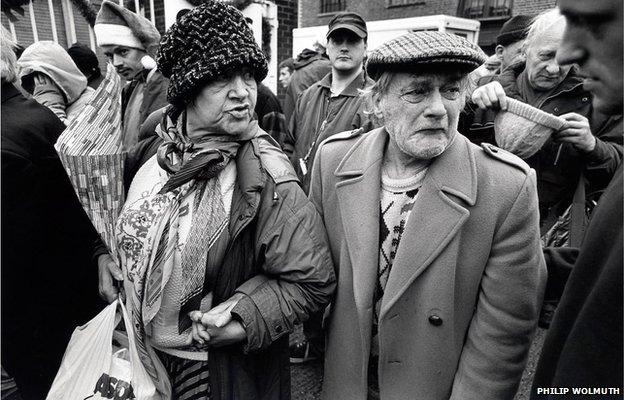 A homeless woman helps a man in need of medical attention into the Crisis Christmas shelter in Bermondsey, South London.