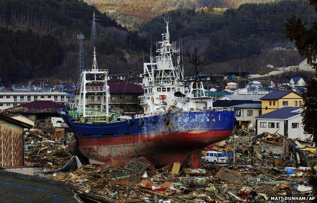 A large vessel stands amongst debris after being washed ashore in Kesennuma