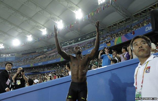 Jamaican sprinter Usain Bolt reacts as he watches the men's 100m final on a big screen after being disqualified for a false start at the World Athletics Championships in Daegu, South Korea