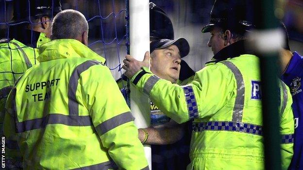 A spectator handcuffs himself to a goalpost during Everton's match with Manchester City at Goodison Park