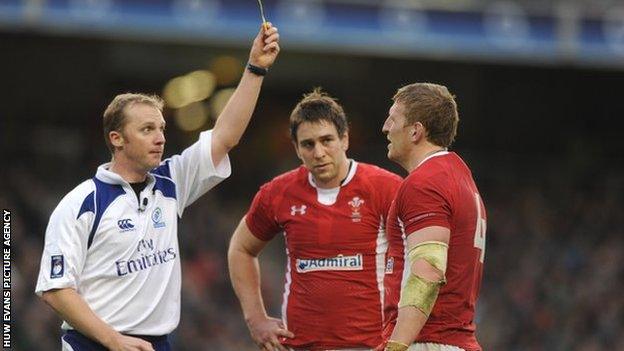 Wales back-row Ryan Jones looks on ruefully as referee Wayne Barnes sin-bins lock Bradley Davies