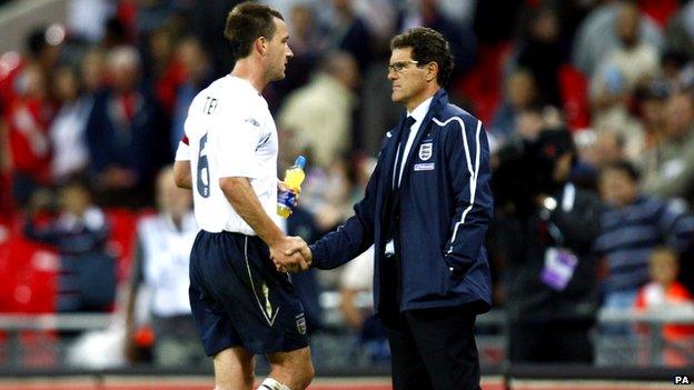Fabio Capello with John Terry on touchline of football field