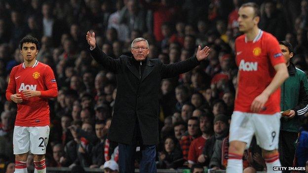 Alex Ferguson holds up his hands while Berbatov walks past him