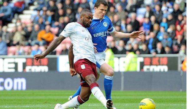 Darren Bent shoots under pressure from Gary Caldwell