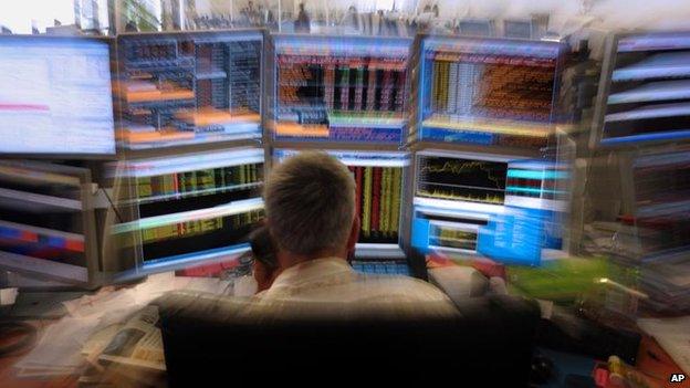 A trader watches screens in his office in an investment house