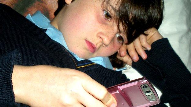 child looking at mobile phone