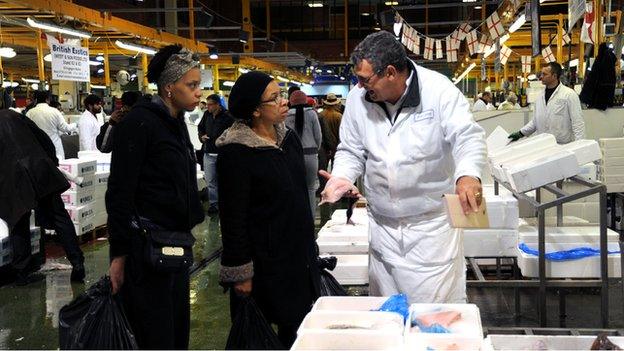 A woman choosing fish to buy at Billingsgate Market