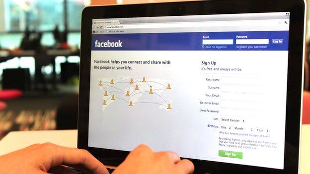 A laptop displaying the Facebook homepage.
