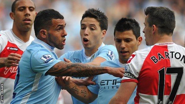 Manchester City striker Carlos Tevez scuffles with QPR captain Joey Barton