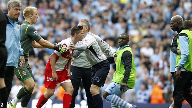 QPR captain Joey Barton is confronted after being sent off