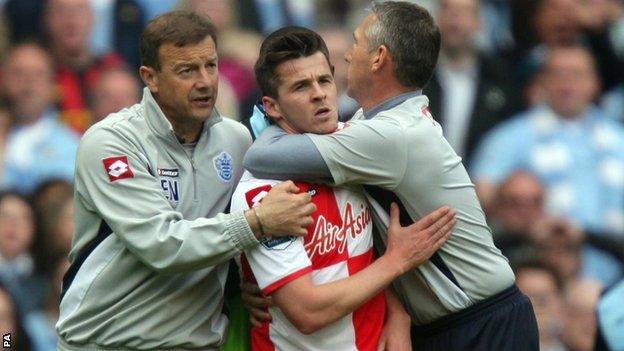 QPR midfielder Joey Barton is restrained after being sent off