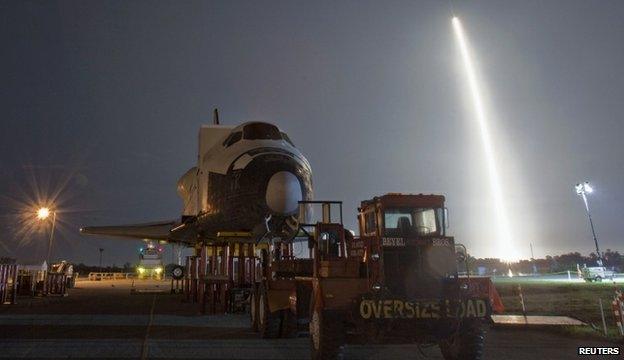 SpaceX launch behind a shuttle model