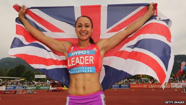 Ennis holding the GB flag above her head.