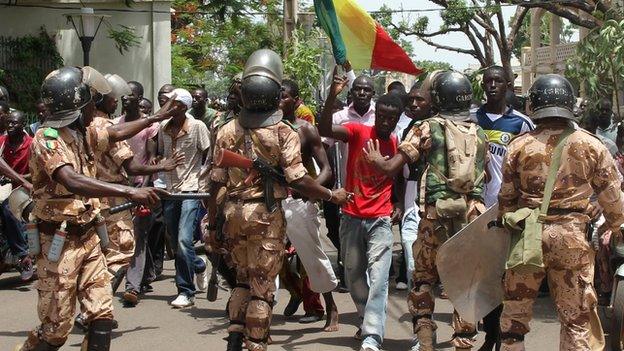 Malian riot police try to prevent demonstrators entering the presidential compound on 21 May