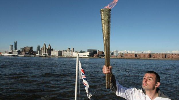 Craig Lundberg carries the Olympic flame on the Mersey Ferry