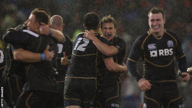 Scotland celebrate their 9-6 win over Australia in a wet and windy Newcastle