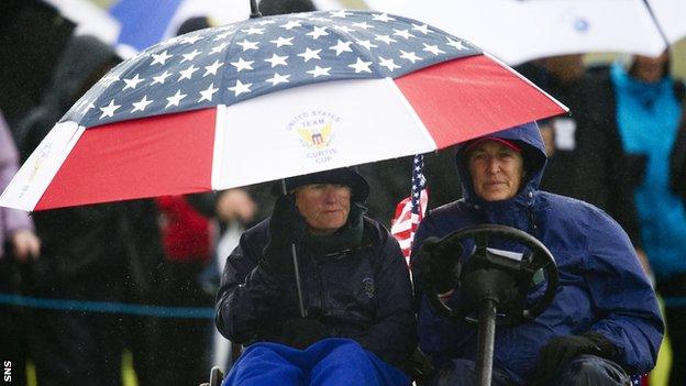 US skipper Pat Cornett (left) shelters under an umbrella as she nurses a broken ankle