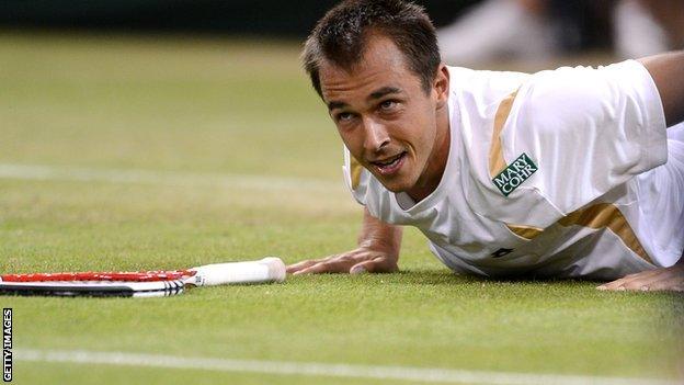 Lukas Rosol lies on the Wimbledon turf