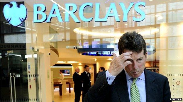 Man scratching his head in front of Barclays sign