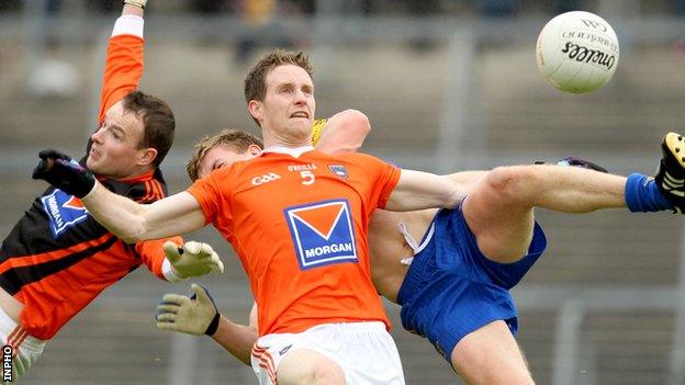 Armagh goalkeeper Philip McEvoy and Finnian Moriarty challenge for the ball with Niall Daly of Roscommon