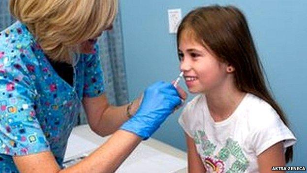 Girl being given flu vaccine nasally