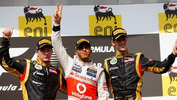 Lewis Hamilton of McLaren celebrates on the podium with second placed Kimi Raikkonen and third placed Romain Grosjean of Lotus