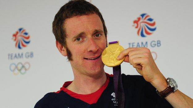 Cyclist Bradley Wiggins holding his London 2012 gold medal