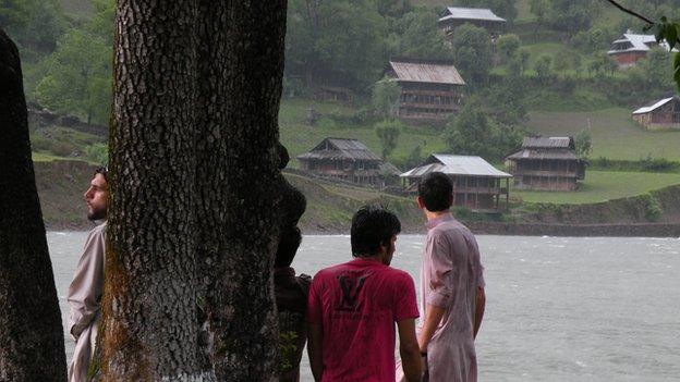 Keran villagers look over the Neelum river at houses on the Indian side