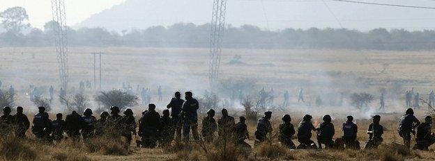 Policemen fire at striking miners at the Marikana platinum mine in South Africa on 16 August