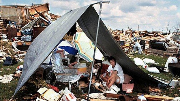 A woman with her dog in a tent admits hurricane rubble