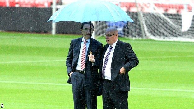 Managers Martin O'Neill and Brian McDermott under an umbrella