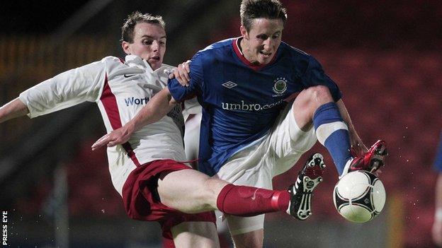 Greg Hall of Ards competes against Linfield's Michael Carvill