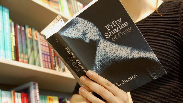 Woman reading Fifty Shades of Grey by EL James