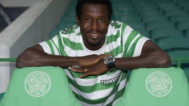 Efe Ambrose tries a Celtic shirt on for size