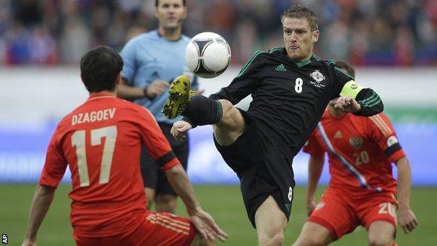 Northern Ireland's Steven Davis gets to the ball before Alan Dzagoev of Russia