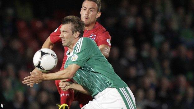 NI defender Gareth McAuley is challenged by Aurelien Joachim