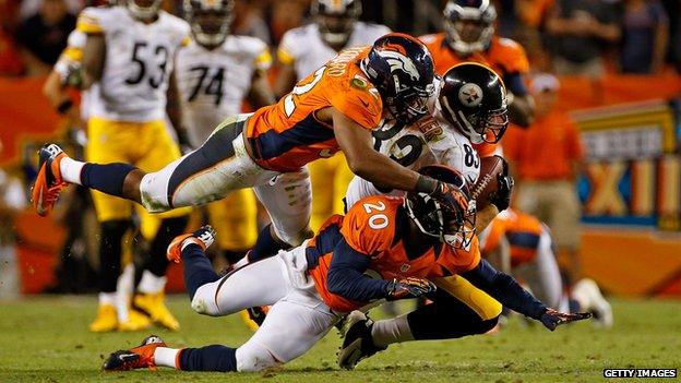 Tight end Heath Miller #83 of the Pittsburgh Steelers makes a reception and is tackled by linebacker Wesley Woodyard #52 and defensive back Mike Adams #20 of the Denver Broncos