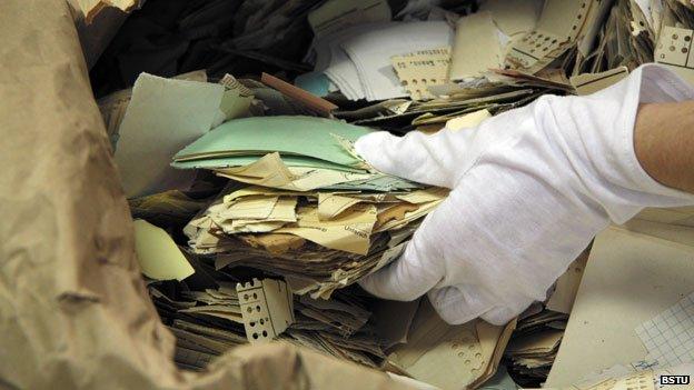 Pulling torn paper fragments from a sack