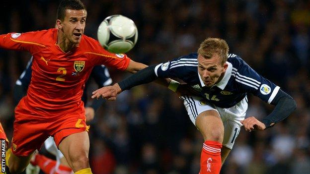 Rhodes sends a header into the side netting against Macedonia