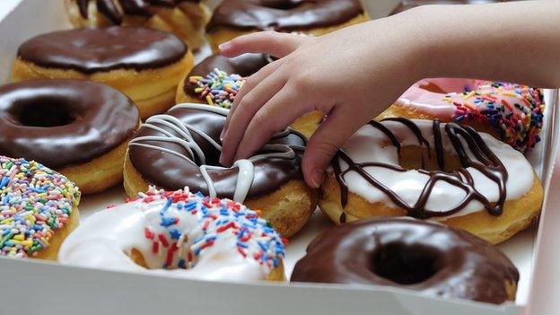 A child's hand on doughnut