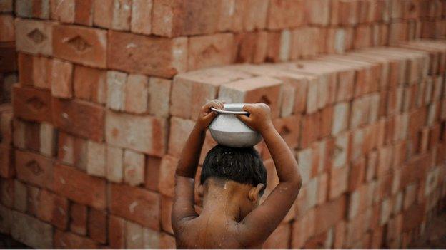 Boy carrying water in quarry