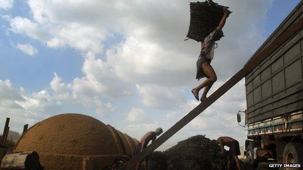 Worker carrying charcoal in Brazil