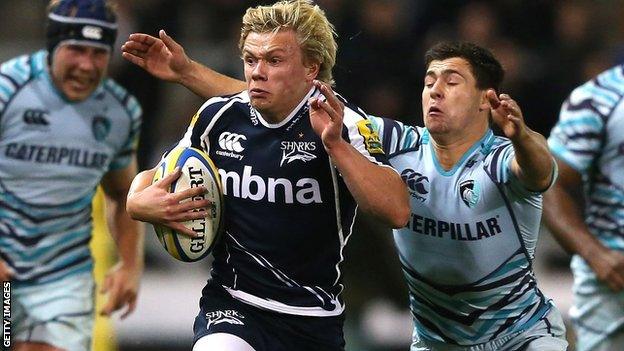 Nathan Fowles of Sale tries to escape the clutches of Ben Youngs