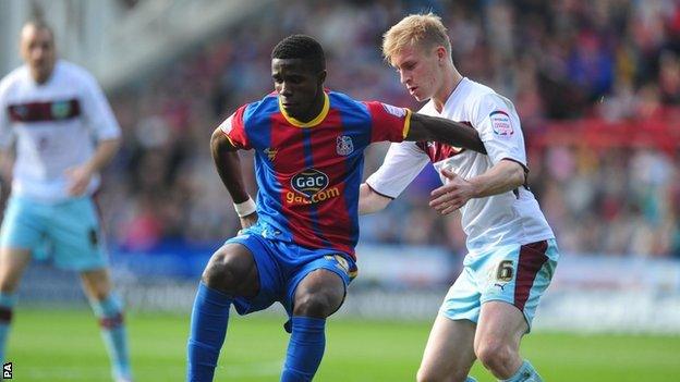 Wilfried Zaha holds off Burnley's Ben Mee