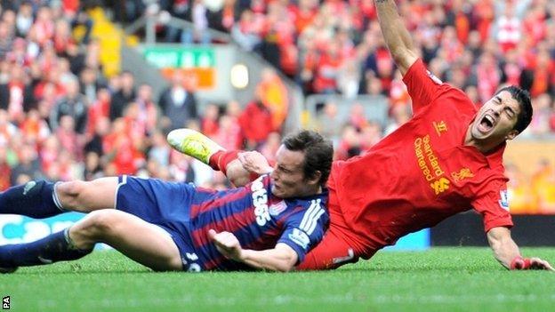 Liverpool's Luis Suarez is challenged by Stoke City's Dean Whitehead (left)