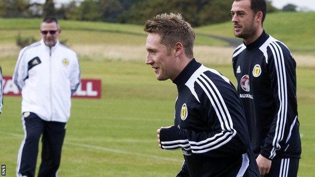 Kris Commons training, with Scotland boss Craig Levein looking on