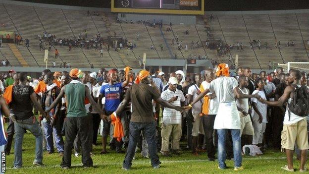 Ivory Coast fans make a ring around each other for safety